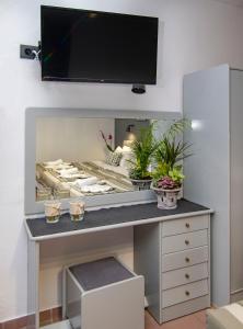 a desk with plants on it with a tv on the wall at Kahlua Hotel Apartments in Rhodes Town