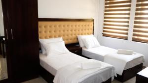 a bedroom with two beds with white sheets at Vivid Colombo in Colombo