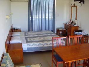 a bedroom with a bed and a table and chairs at Palmasol Hotel in Triánta