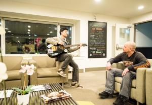 a man playing a guitar in a waiting room at HI Calgary City Centre - Hostel in Calgary