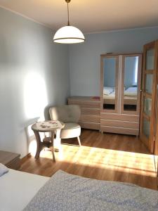 sypialnia z łóżkiem, krzesłem i stołem w obiekcie Apartament Sopot Kraszewskiego w mieście Sopot