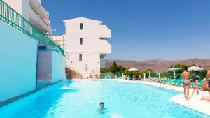 een zwembad in een hotel met mensen in het water bij Apartamentos Monteparaiso in Puerto Rico de Gran Canaria