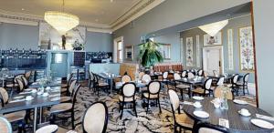 um restaurante com mesas e cadeiras num quarto em Tynemouth Grand Hotel em Tynemouth