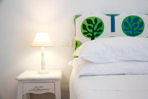 a white bed with a lamp on a white nightstand at Casa Sorrentina in Sorrento