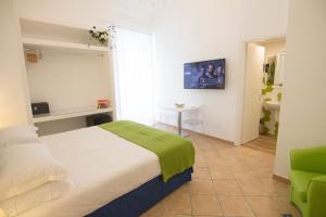 a bedroom with a bed and a green chair at Casa Sorrentina in Sorrento