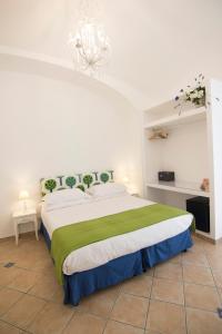 a bedroom with a large bed and a chandelier at Casa Sorrentina in Sorrento