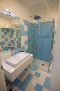 La salle de bains est pourvue d'un lavabo et d'une douche en verre. dans l'établissement Casa Sorrentina, à Sorrente