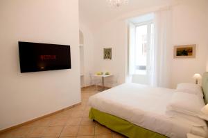 a bedroom with a bed and a television on a wall at Casa Sorrentina in Sorrento