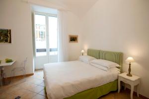 a bedroom with a white bed and a window at Casa Sorrentina in Sorrento