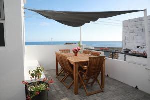 a table and chairs on a balcony with a view of the ocean at Vista do Cais in Lagoa