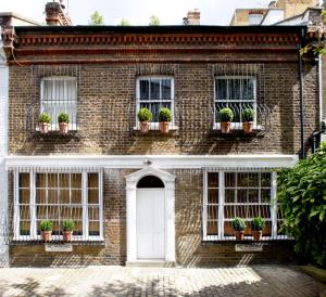 a brick house with potted plants on the windows at Blakes Hotel in London