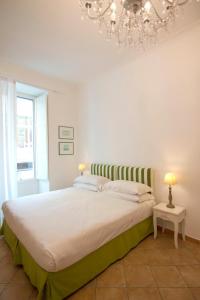 a bedroom with a large bed with a chandelier at Casa Sorrentina in Sorrento