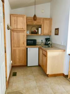 a kitchen with wooden cabinets and a white refrigerator at Mountain Shadows Resort in Estes Park