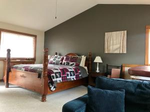 a bedroom with a bed and a chair at Mountain Shadows Resort in Estes Park