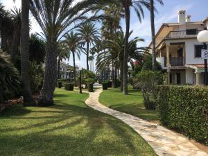 une passerelle traversant une pelouse avec des palmiers dans l'établissement Frente al Mar. Atlantic, à Dénia