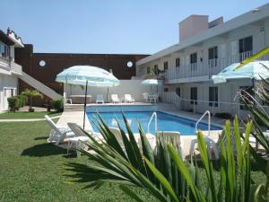 Una piscina con sillas y sombrillas al lado de un edificio. en AOHOM SANTUARIO HOTEL & SPA, en Jiutepec