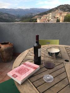 uma mesa de madeira com uma garrafa de vinho e um copo em Cal Don Juan em Torroja