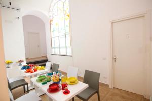 een eetkamer met 2 tafels en stoelen en een raam bij Casa Sorrentina in Sorrento