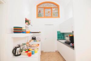 a kitchen with white walls and a white counter top at Casa Sorrentina in Sorrento