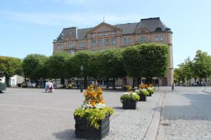 a building with a bunch of flowers in a courtyard at Grand Hotel Jönköping in Jönköping