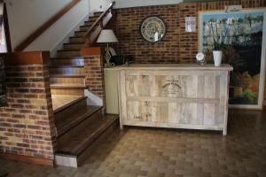 eine Treppe in einem Haus mit Holztür und Ziegelwand in der Unterkunft La Truffiere in Puy-lʼÉvêque