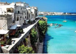 a group of buildings on a cliff next to the water at Casa in SALENTO a Otranto in Otranto