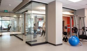 a gym with glass walls and people exercising in it at Parkside Student Residence Downtown Toronto in Toronto