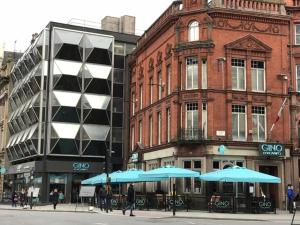 two blue umbrellas on a city street with buildings at Beatles Apartment in Liverpool