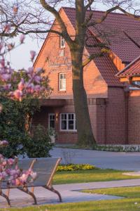 a bench in front of a building with a tree at Visbeker Deern Hotel Garni in Visbek