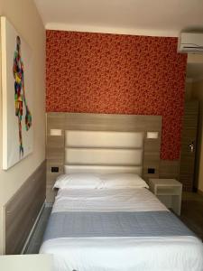 a bedroom with a large bed with a red wall at Aparthotel San Gregorio 45 in Milan