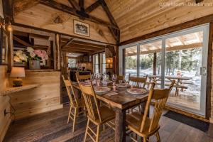 a dining room with a table and chairs in a cabin at Le Ross - Les Chalets Spa Canada in La Malbaie