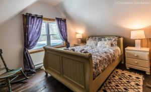 a bedroom with a bed and a window at Le Ross in La Malbaie