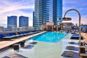 a pool on the roof of a building with chairs and buildings at Stay Together Suites on The Strip - 2 Bedroom Suite 976 in Las Vegas