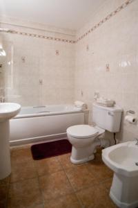 y baño con aseo, bañera y lavamanos. en The Ritz House, en Lisdoonvarna