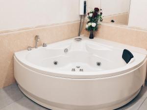 La salle de bains est pourvue d'une baignoire blanche et d'un vase de fleurs. dans l'établissement Ban Don Holidayhome, à Thalang