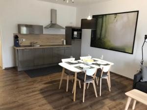 een keuken en eetkamer met een tafel en stoelen bij Ferienwohnung Kirschholz in Schmelz