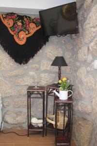 a room with two tables and a tv on a wall at Casinha da Raposeira in Soajo