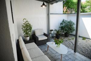 a patio with a couch and a table and plants at Rába Apartman House in Győr