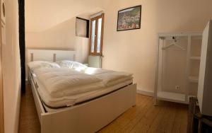 a white bed in a room with a window at Ferienhaus Am Balduinstor in Cochem