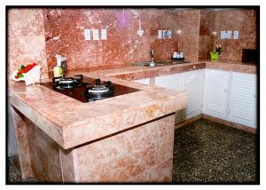 a kitchen with a marble counter top with a stove at Hostal "Villa Blanca" in Caibarién