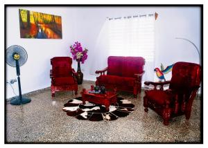 a living room with two red chairs and a table at Hostal "Villa Blanca" in Caibarién