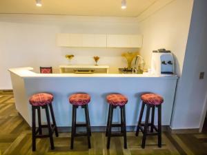a kitchen with a counter with stools in front of it at Estrela do Sul Hotel in Curitiba