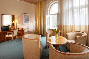 フランチシュコヴィ・ラーズニェにあるDr. Adler Spa & Kurhotelのテーブルと椅子が備わるホテルルームです。