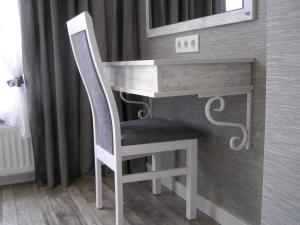 einen Stuhl neben einem Schreibtisch in einem Zimmer in der Unterkunft Panorama Lviv in Lwiw