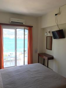 a bedroom with a bed and a view of the ocean at Hotel Papasotiriou in Galatas