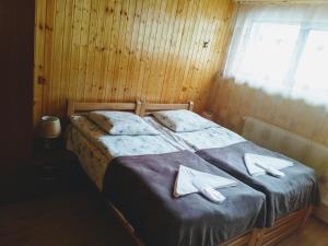 a bedroom with a bed with two napkins on it at mariami in Stepantsminda