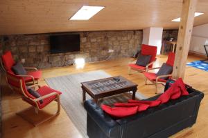 a living room with a couch and chairs and a tv at La casa de la Petra in Quintanar de la Sierra