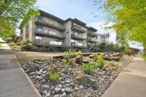 an apartment building with a rock garden in front of it at Sea View, Best Area, No Stairs, WD, 2 Bedrooms, Jacuzzi Bath, New Carpet, Balcony, View, 825sf in Tacoma