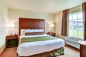 a hotel room with a large bed and a window at Cobblestone Inn & Suites - Rugby in Rugby