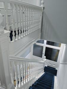 a staircase with white railings and a blue stair at Falcon Crest Guest House in Edinburgh